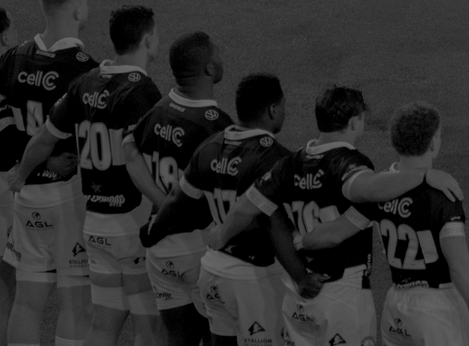 Hollywoodbets Sharks XV players stand together in a team huddle, seen from behind.