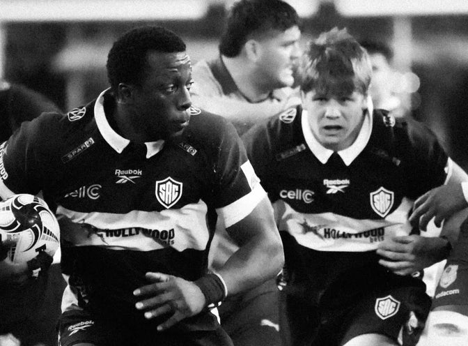 A Hollywoodbets Sharks XV ball carrier drives forward with team-mates in support.