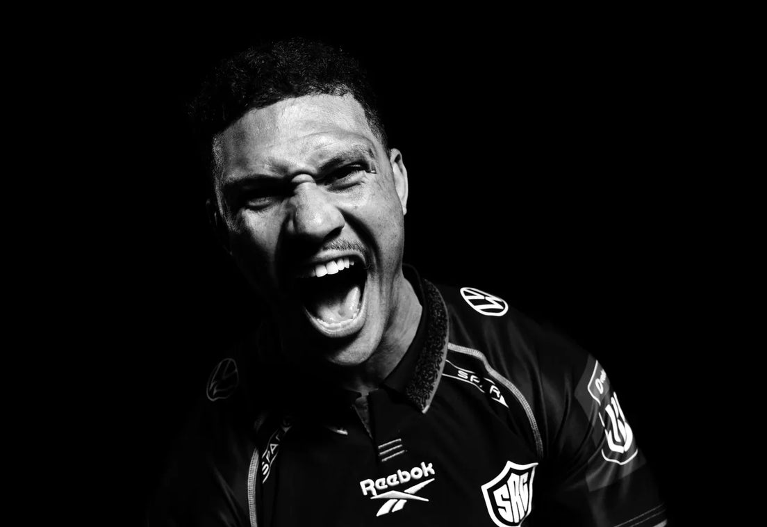 Hollywoodbets Sharks wing Edwill van der Merwe roars at the camera in a black-and-white studio portrait, wearing the Sharks jersey against a black background.