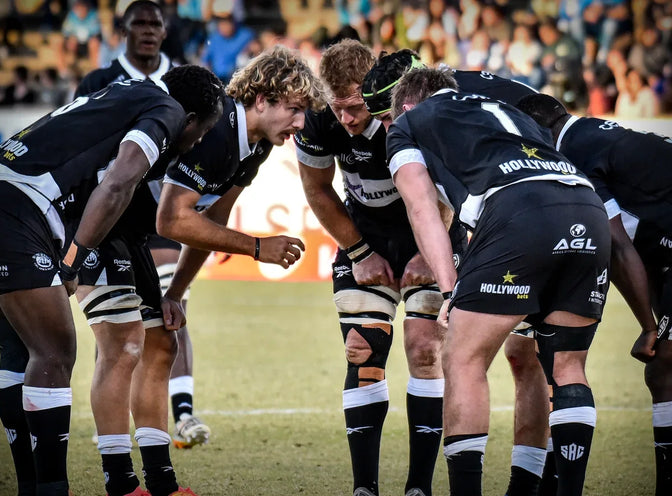Hollywoodbets Sharks XV forwards bind together before a scrum in front of a full stand.