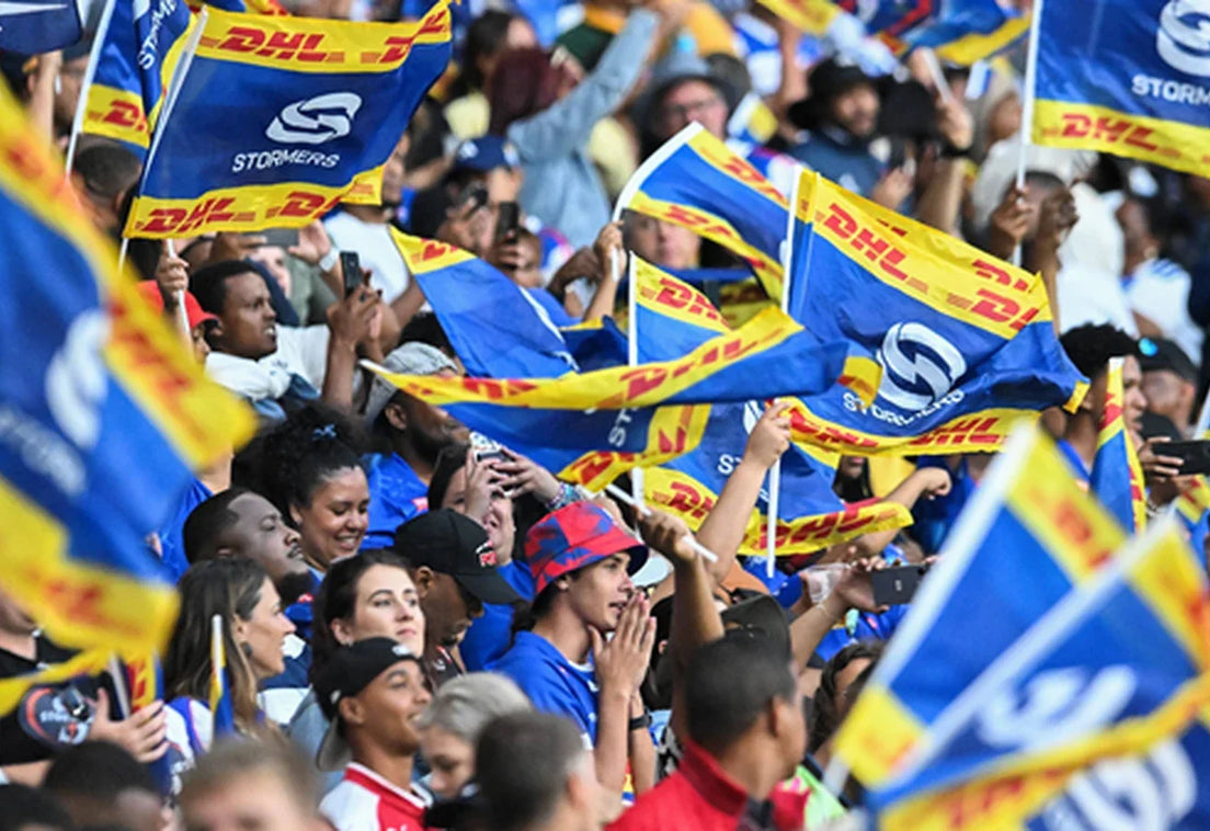DHL Stormers supporters packed into the stand at DHL Stadium, waving a sea of blue and yellow Stormers flags.