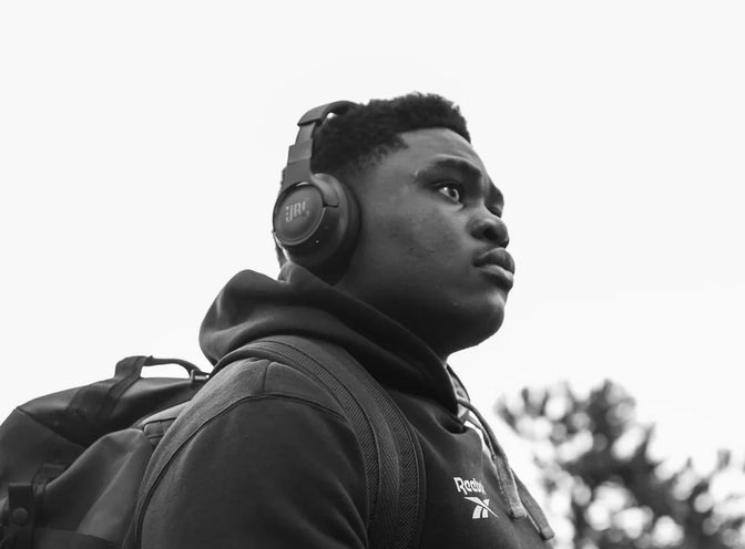 A Hollywoodbets Sharks player arrives at the stadium wearing headphones and a backpack.