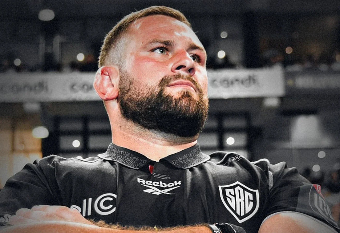 Sharks prop Thomas du Toit stands with arms folded in the black Sharks jersey, looking up into a packed stadium.