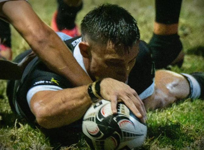 A Hollywoodbets Sharks XV player grounds the ball over the line under a defender's tackle.